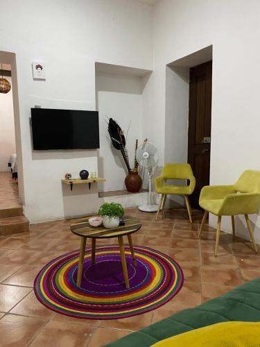 a living room with a table and a tv at Casa Ceiba/Dpto. entero cerca del Centro Histórico in Oaxaca City