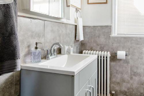 a bathroom with a white sink and a radiator at 2 Bedrooms at the heart of the City! Full Comfort! in Washington, D.C.