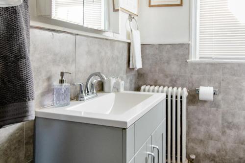 a bathroom with a white sink and a radiator at Comfort & Cozy 2BR Family Stay at Downtown Washington DC in Washington, D.C.