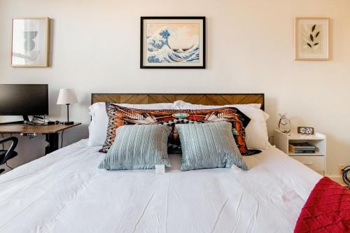 a bedroom with a white bed with two pillows at Comfort & Cozy 2BR Family Stay at Downtown Washington DC in Washington, D.C.