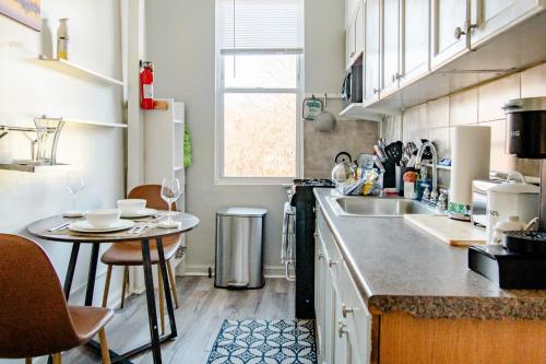 a small kitchen with a sink and a table at Comfort & Cozy 2BR Family Stay at Downtown Washington DC in Washington, D.C.