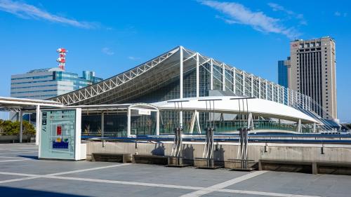 a train station with a building in a city at Toyoko Inn Chiba Makuhari in Chiba