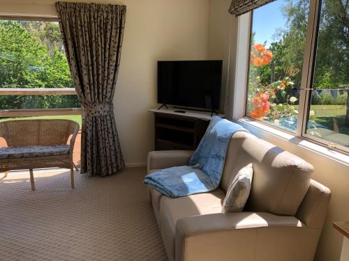 a living room with a couch and a television at Jennifer's Cottage in Reidston