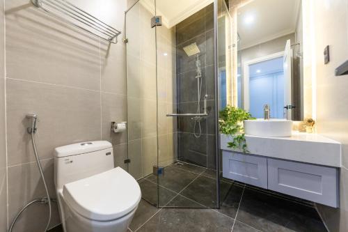 La salle de bains est pourvue de toilettes, d'un lavabo et d'une douche. dans l'établissement Joyce Boutique Coffee & Stay, à Đà Lạt
