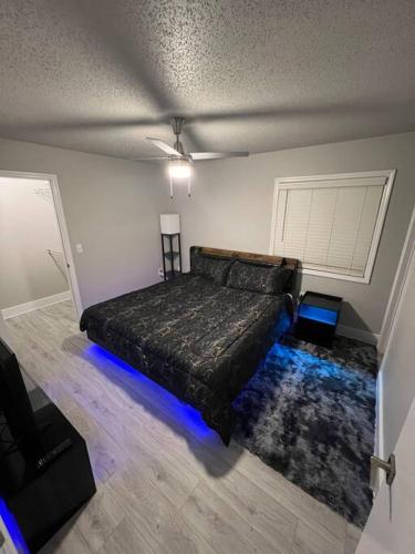 1 dormitorio con 1 cama con luces azules en el suelo en Cozy LED Condo: 2BR, 2BA Apt, en Charlotte