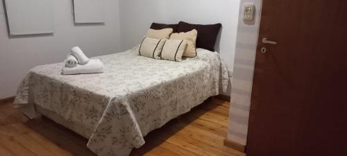 1 dormitorio con 1 cama con manta blanca y almohadas en Dpto Tiempo Presente en Colón