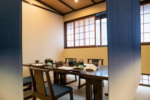 a room with a table with chairs and windows at 岩井温泉　岩井屋 in Iwamicho