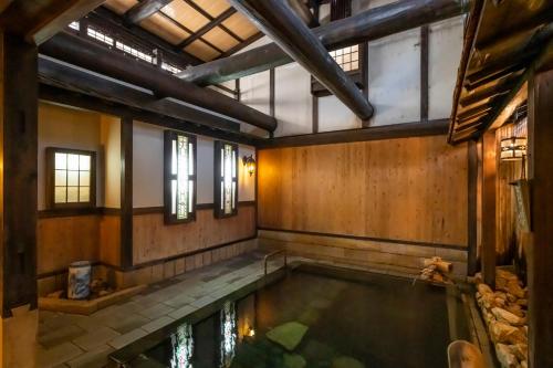 an indoor swimming pool in a building with windows at 岩井温泉　岩井屋 in Iwamicho