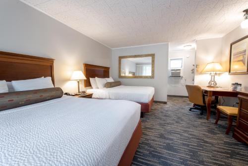 a hotel room with two beds and a desk at Scotty's Lakeside Resort in Lake George
