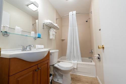 a bathroom with a sink and a toilet and a shower at Scotty's Lakeside Resort in Lake George