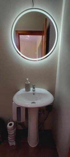 ein Badezimmer mit einem weißen Waschbecken und einem Spiegel in der Unterkunft ENCANTADORA CABAÑA DEL BOSQUE in San José