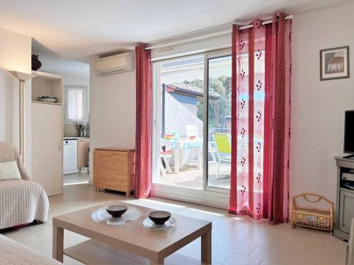 un salon avec une table et une grande fenêtre dans l'établissement Appt Climatisé avec Piscine, 6 Couchages, Proche Plage, 2 Terrasses, Parking – Le Lavandou - FR-1-251-551, au Lavandou