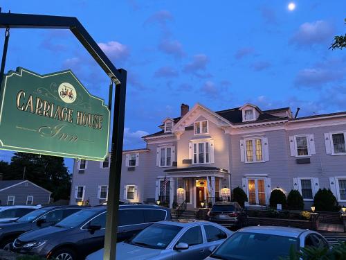 a sign in front of a large house at The Carriage House Inn Newport in Middletown