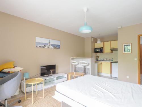 Cet appartement comprend une chambre avec un lit blanc et une cuisine. dans l'établissement Studio ensoleillé au bord de mer avec balcon et parking, proche centre et plage - La Rochelle - FR-1-535-51, à La Rochelle