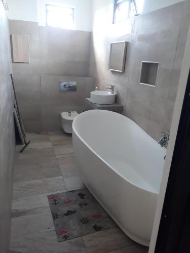 uma casa de banho com um WC, uma banheira e um lavatório. em PREM VILLA em Petit Raffray