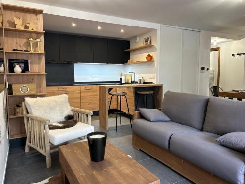 un salon avec un canapé et une cuisine dans l'établissement Chaleureux duplex aux Gets - Proche des pistes et des commerces, 8 couchages, WiFi, parking inclus - FR-1-623-355, aux Gets