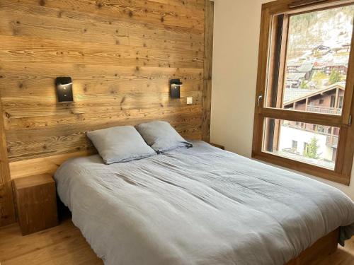 een bed in een slaapkamer met een houten muur bij Appartement Les Gets, 4 pièces, 8 personnes - FR-1-623-355 in Les Gets