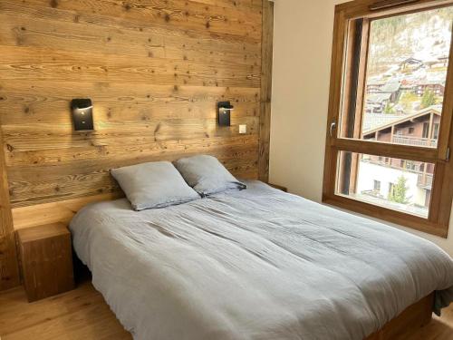Ce lit se trouve dans une chambre dotée d'un mur en bois. dans l'établissement Chaleureux duplex aux Gets - Proche des pistes et des commerces, 8 couchages, WiFi, parking inclus - FR-1-623-355, aux Gets