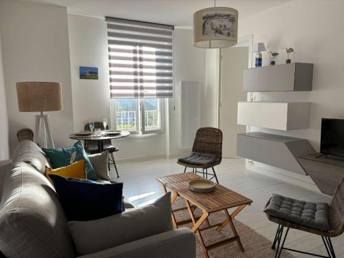 un salon avec un canapé, des chaises et une télévision dans l'établissement Appartement T2 en bord de mer à Pontaillac - 4 pers, cuisine équipée, WiFi, proche commerces - FR-1-494-168, à Royan