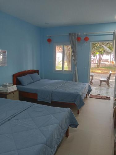 a bedroom with two beds and a window at Biển Ngọc Homstay in Ấp Sung Xuân