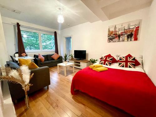 a bedroom with a red bed and a living room at 2 Bed flat near to London Bridge in London