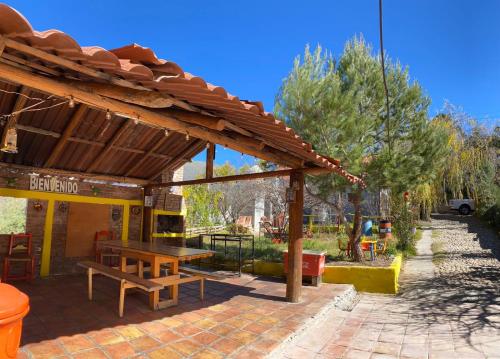 Cabaña San Juanita في Los Lirios: جناح خشبي مع طاولة وكراسي خشبية