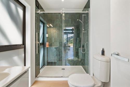 a bathroom with a shower and a toilet and a sink at The Cabin - Wellington Holiday Home in Wellington