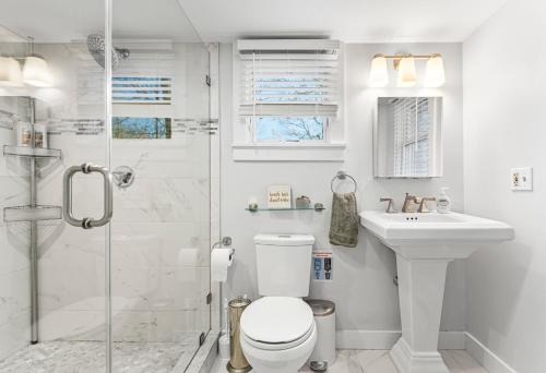 a bathroom with a toilet and a sink and a shower at Fresh Pond Chateau Renovated Bright and Cozy Home in Oak Bluffs