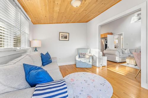 a living room with a gray couch and blue pillows at Fresh Pond Chateau Renovated Bright and Cozy Home in Oak Bluffs