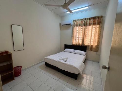 1 dormitorio con 1 cama y ventilador de techo en Al-Ahsan Homestay, en Pasir Gudang