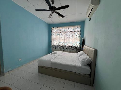 a bedroom with a bed with a ceiling fan at Al-Ahsan Homestay in Pasir Gudang