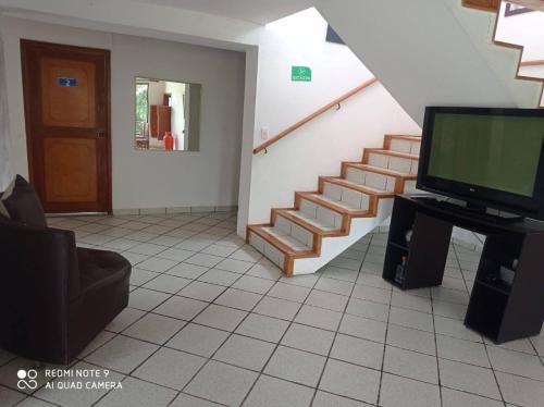 uma sala de estar com televisão e uma escadaria em Finca Anapoima Tranquila em La Mesa
