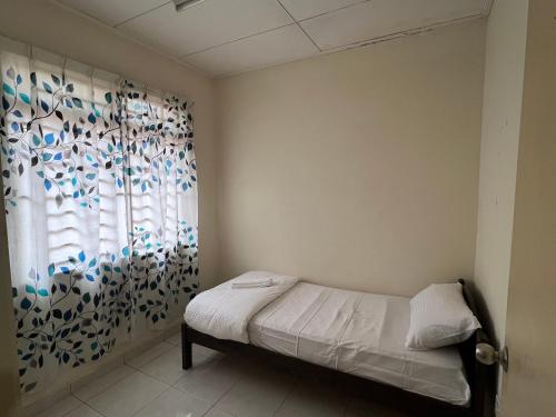 sypialnia z łóżkiem i oknem w obiekcie Al-Ahsan Homestay w mieście Pasir Gudang