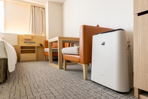a room with a chair and a small refrigerator at Tokyu Stay Aoyama Premier in Tokyo