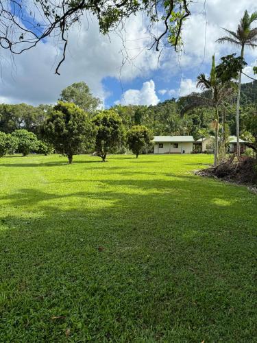 a large grass field with a building in the background at Ahana Resort in Fishery Falls