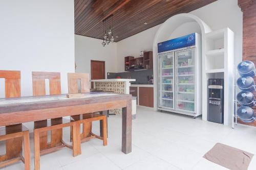 uma cozinha com uma mesa grande e um frigorífico em Pondok DD Canggu em Canggu