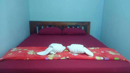 two white pillows on a bed with a red blanket at chill chill long beach hostel in Ko Lanta