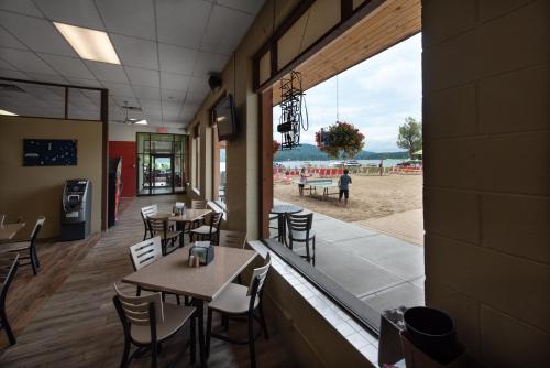 a restaurant with tables and chairs and a view of the beach at Scotty's Lakeside Resort in Lake George