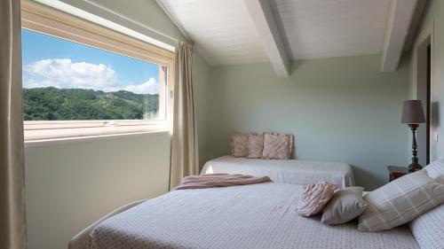 Un dormitorio con dos camas y una ventana. en Chipieri, en Piobbico