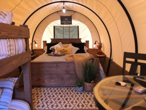 a room with a bed in a tent with a table at Eycat Lodging Company in Wapiti