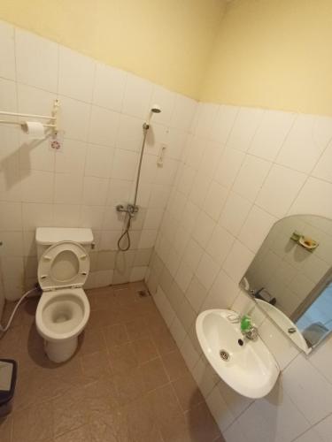 a bathroom with a toilet and a sink at The Swarna Hotel Bayah Lebak in Muaramadur