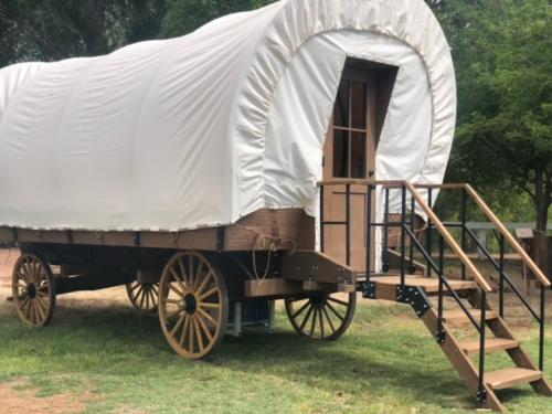 an old wagon with a tent in a field at Eycat Lodging Company in Wapiti