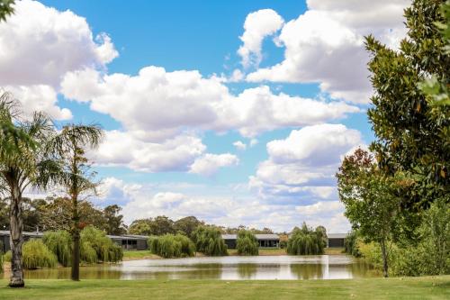 a park with a lake and clouds in the sky at Moama Waters in Moama