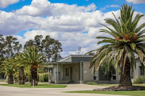 a building with palm trees in front of it at Discovery Parks - Moama Waters in Moama