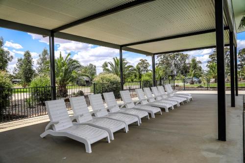 a row of white chairs sitting under a pavilion at Discovery Parks - Moama Waters in Moama