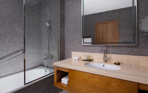 a bathroom with a sink and a shower at DoubleTree by Hilton Almaty in Almaty