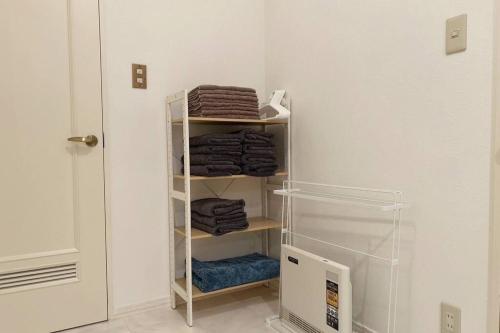 een handdoekenrek in een kamer met handdoeken bij Kitamachi Home in Higashikawa