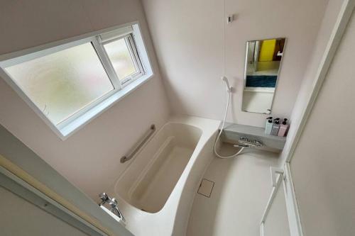 a bathroom with a sink and a mirror at Kitamachi Home in Higashikawa