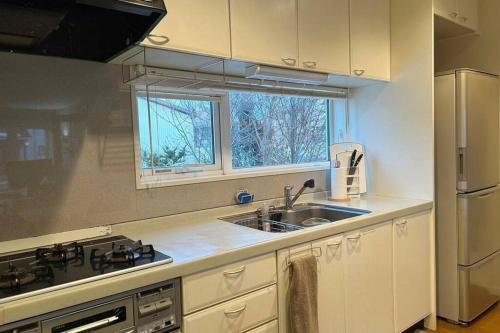 a kitchen with a sink and a stove at Kitamachi Home in Higashikawa
