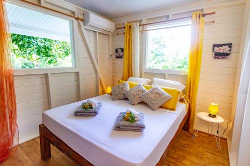 - une chambre avec un lit blanc et 2 fenêtres dans l'établissement Bord de Rivière & Piscine Privée - TiKaz Twopikal, à Sainte-Rose